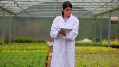 Woman-standing-at-the-greenhouse-holding-a-clipboard