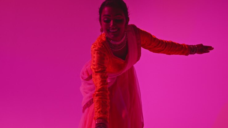 Studio Shot Of Female Kathak Dancer Performing Dance Wearing Traditional Indian Dress Against Purple Background 2