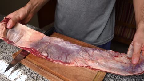 Cook-preparing-raw-flank-beef-for-cooking-on-the-grill