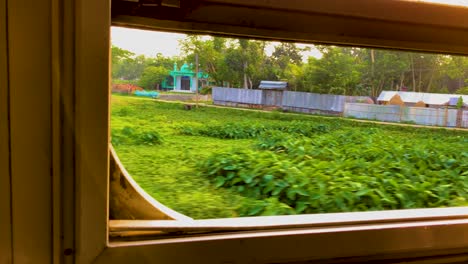 vista de una aldea rural a través de la ventana de un tren que viaja en bangladesh