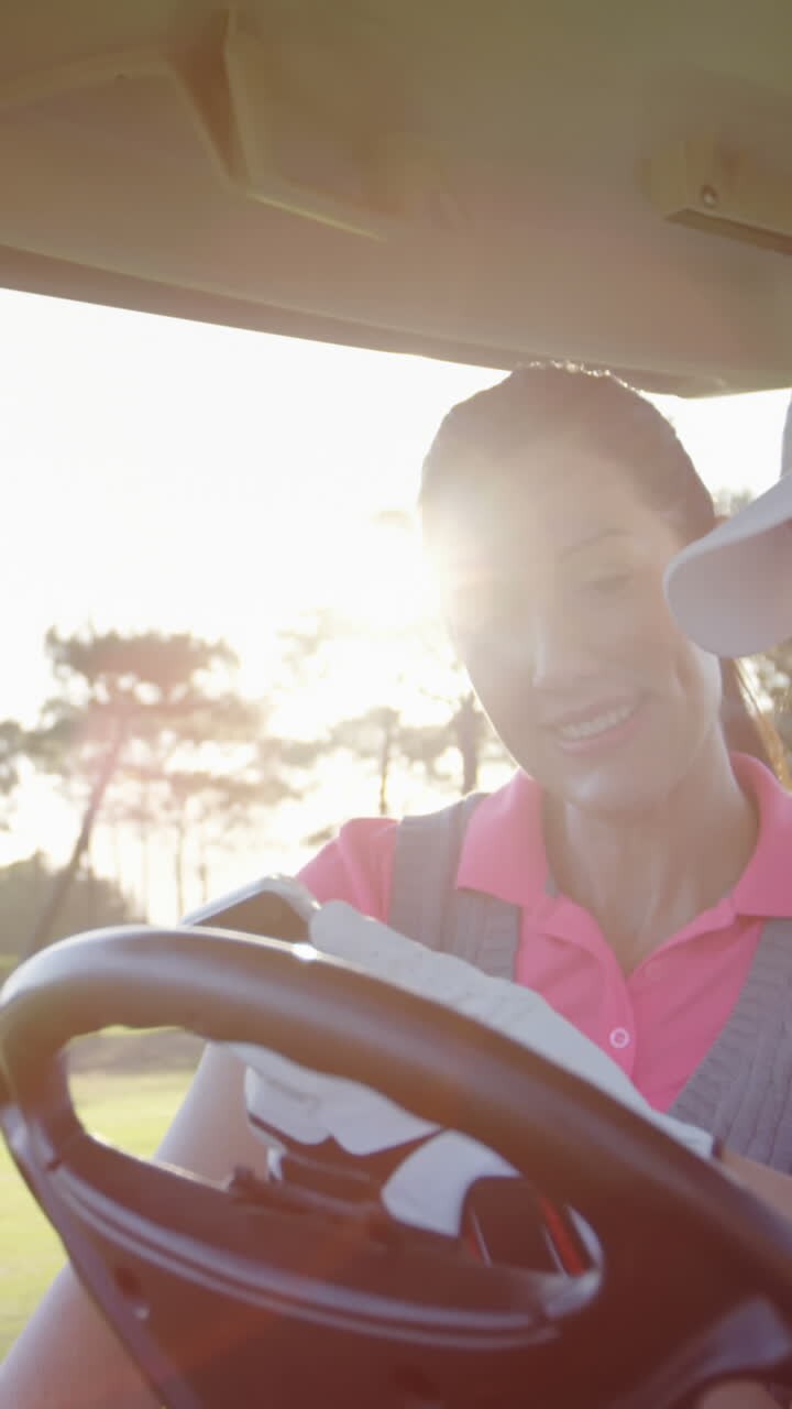 Golfisti seduti su un golf cart che usano il cellulare