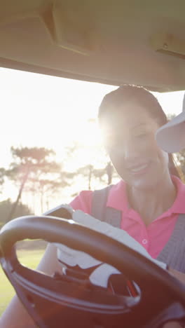 golfistas sentados en un buggy de golf usando un teléfono móvil