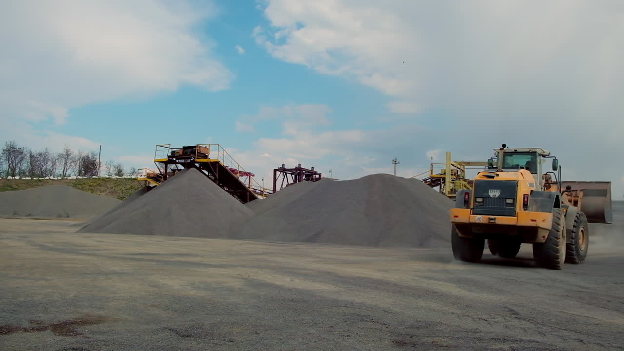 Industrial machinery working at quarry. Wheel loader machine loading crushed stones