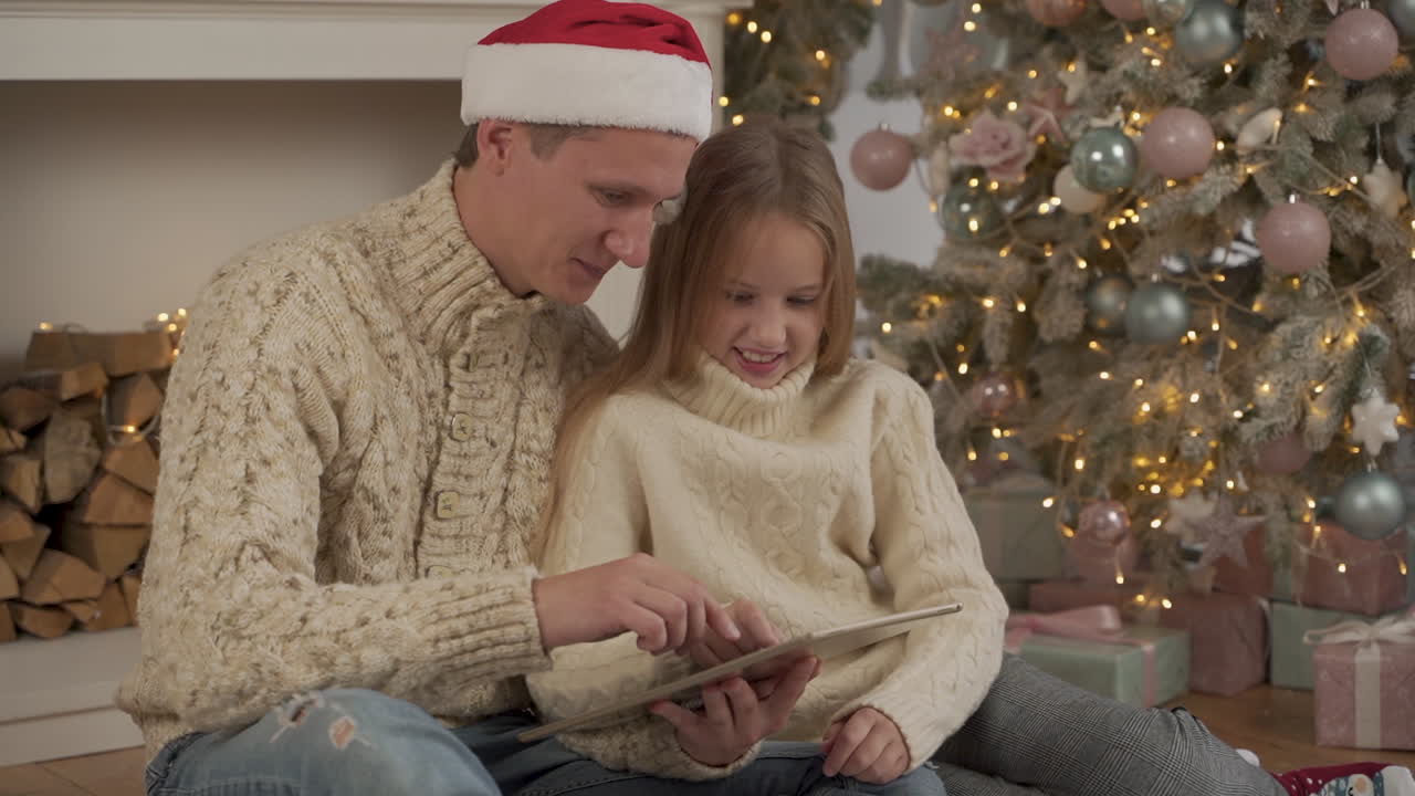 familia feliz usando una tableta en navidad con un sombrero de santa