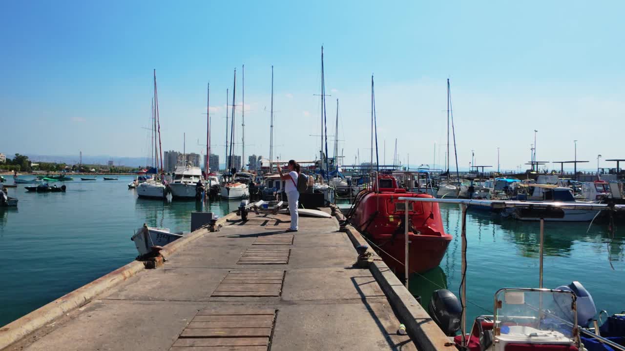 Side view of woman along concrete pier in historic harbor