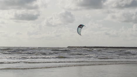 kite surfer surfing over sea and jumping up in slow motion