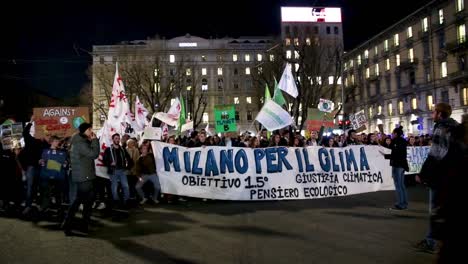 global strike for climate change. thousands of people attend and fill streets in piazzale cadorna milan. youth guys raise placard and their voice for friday for future with greta thunberg