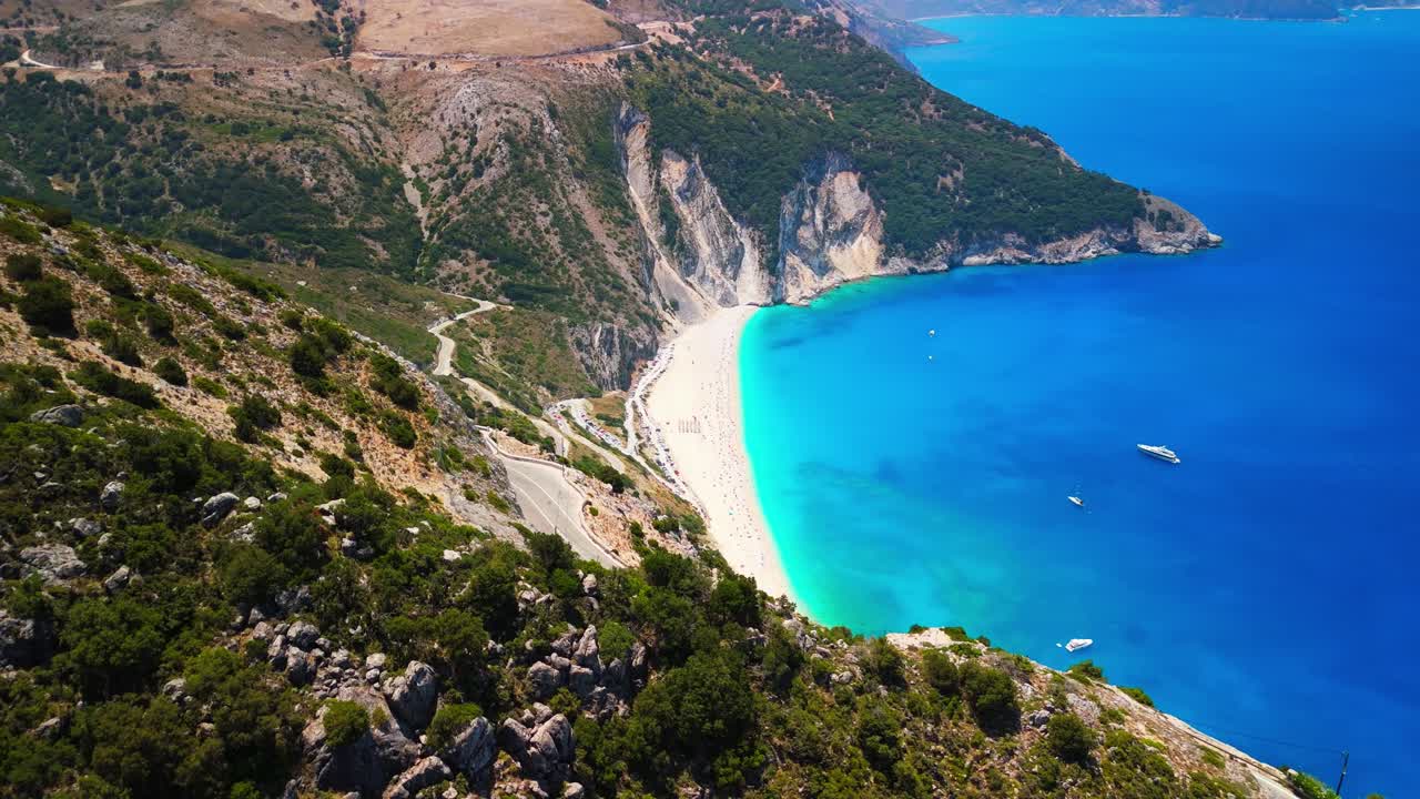 Drone Aerial and Cinematic View of the Myrtos Beach in Kefalonia. One of the most spectacular beaches in Greece and the Mediterranean. Surrounded by steep cliffs and lush green hills. DJI MINI 4PRO