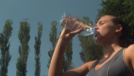 athletic sporty woman drinking a bottle of water