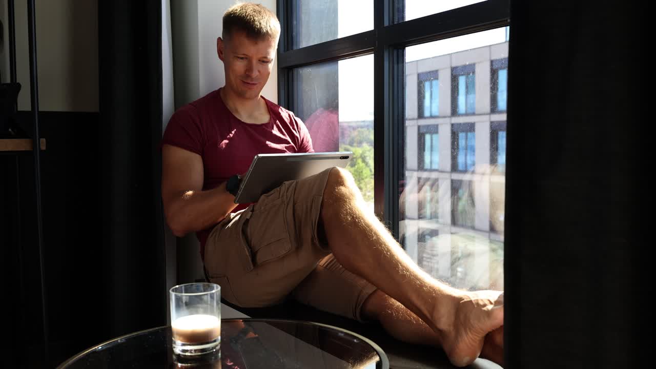Man using tablet by the window