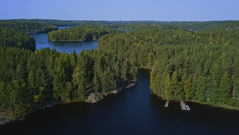 floating bridge on ropes over a lake or a stream in a forest, summer, aerial epic wide shot with islands, lakes and forest