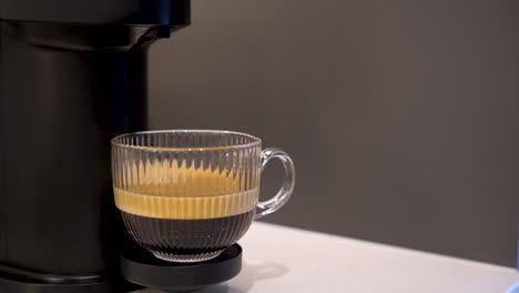 mano masculina recogiendo un café negro de una máquina de espresso