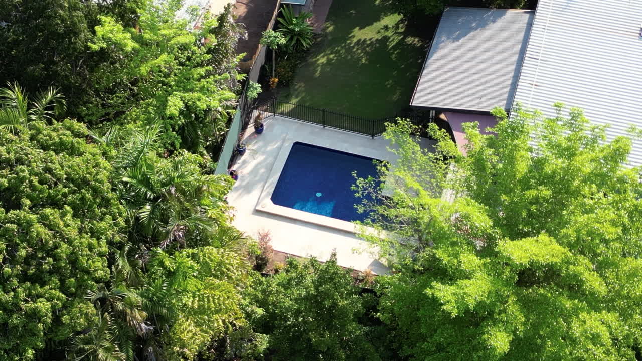 Aerial Drone Luxurious Property in Residential Suburb neighbourhood with large yard and tropical green palm trees