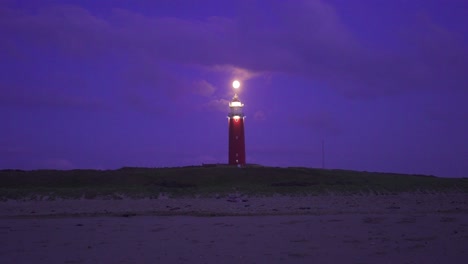 large red metal lighthouse located on the coast illuminated warning any vessel of the presence of land recorded while it was getting dark