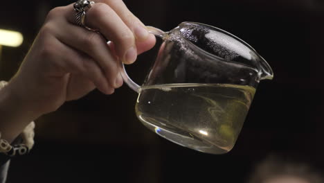 hand pouring glass tea