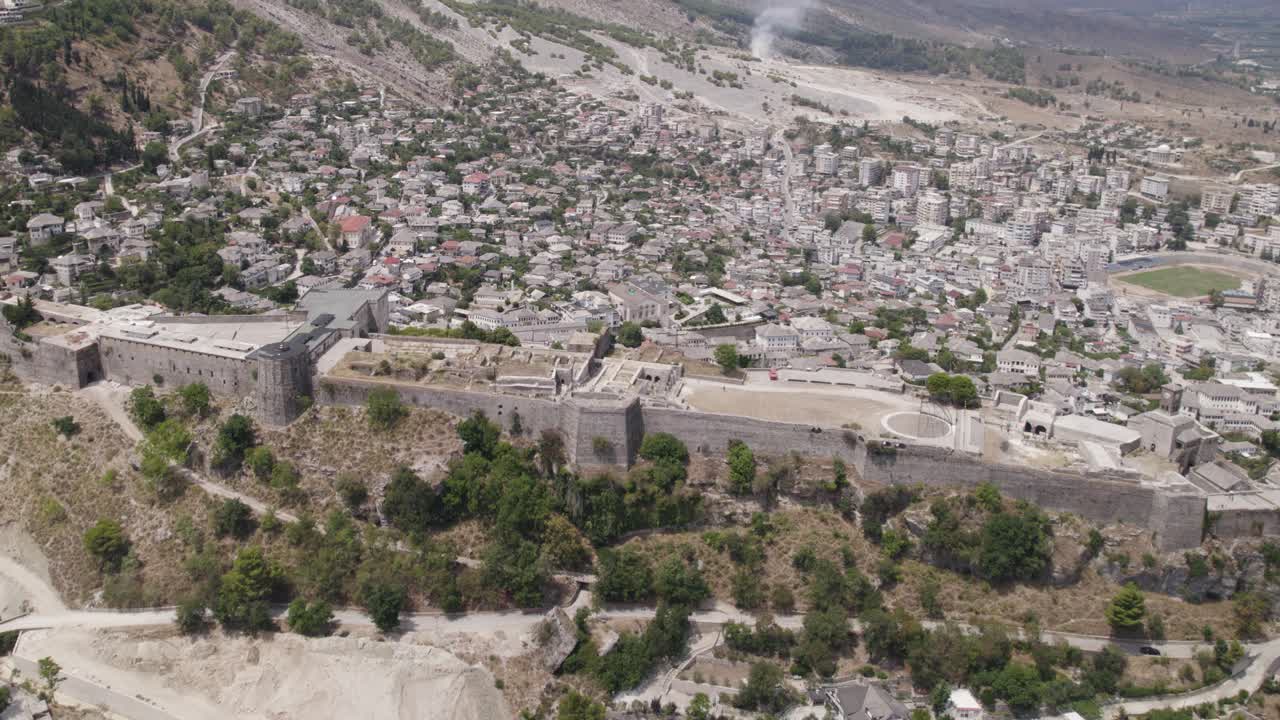 vista aérea en órbita sobre el castillo de gjirokaster hito histórico albanés con paisaje urbano en segundo plano