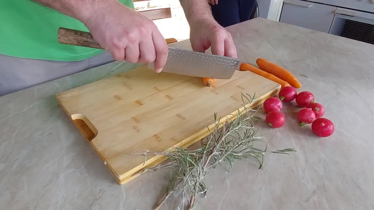 cortar zanahorias de naranja en un plato de madera