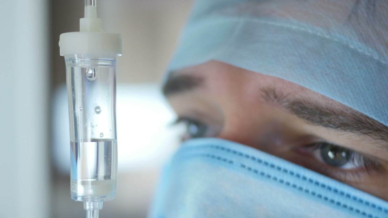 Primo piano di flebo con professionista medico sullo sfondo