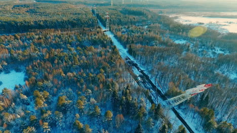 process installing high voltage tower in forest. high voltage power lines