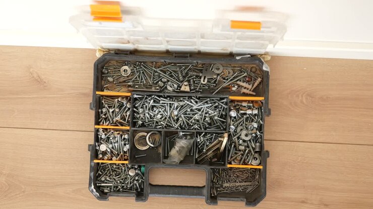 A close-up of a toolbox full of screws, nails, and other hardware