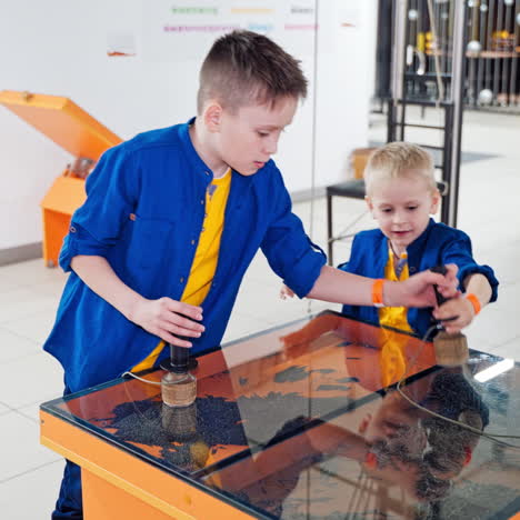 children playing with sand and iron powder in entertaining and educative centre