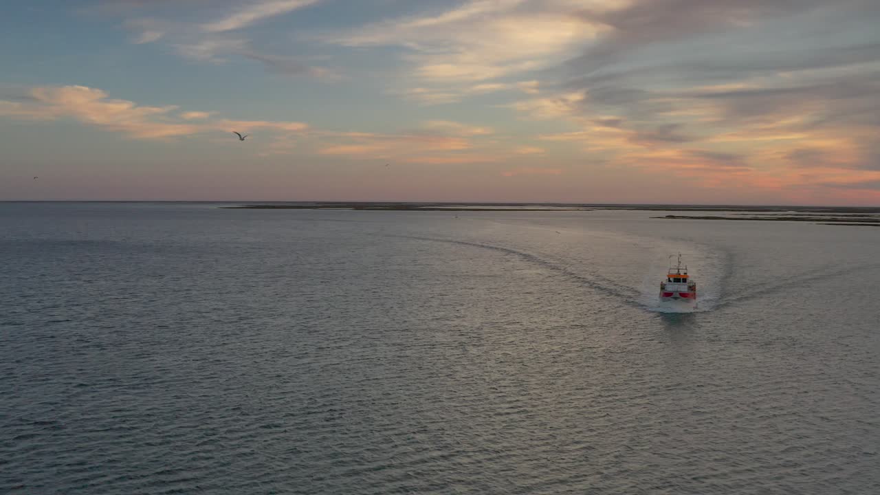 puesta de sol sobre una vía fluvial con un barco