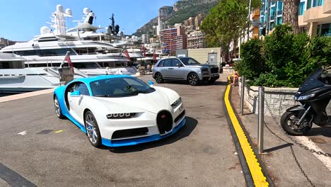 luxury car driving by yachts in monaco