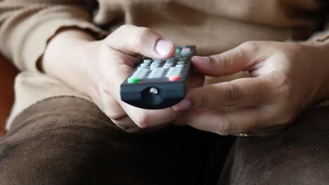 close-up of a person holding a tv remote control