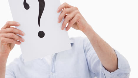 caucasian businessman holding question mark sign over face