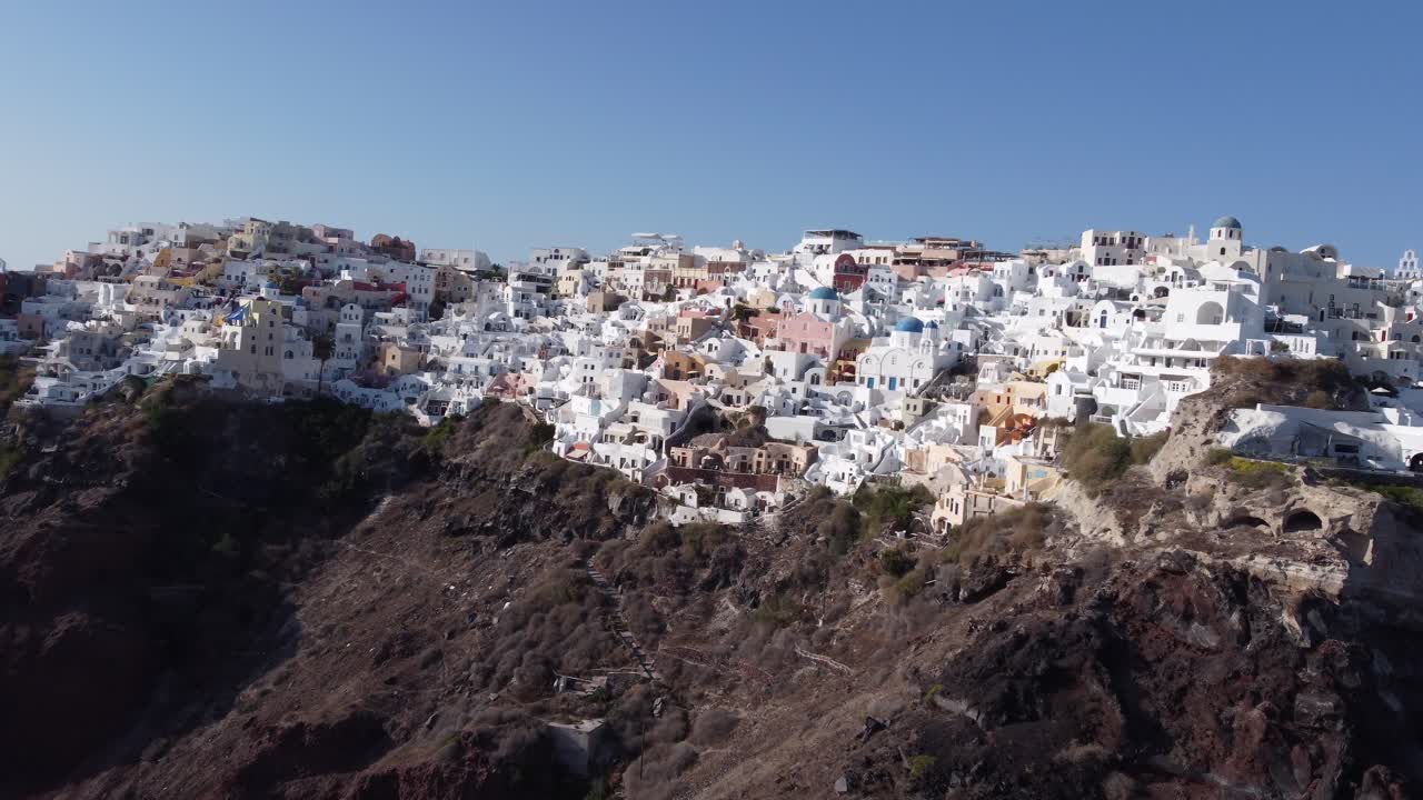 vuelo sobre las tradicionales villas blancas adosadas ini village oia, santorini, grecia