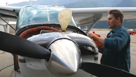 engineer filling oil in aircraft engine 4k