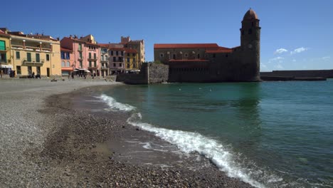 Notre-Dame-des-Anges-church-jutting-out-into-the-bay-of-Collioure-in-the-south-of-France-on-a-hot-windy-day