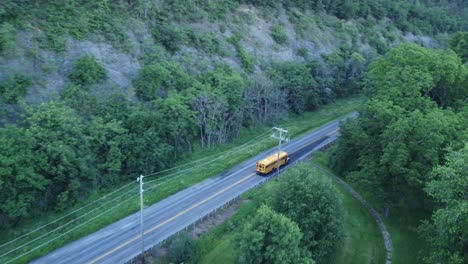 conducción de autobuses escolares en la carretera secundaria rural en terrenos forestales montañosos