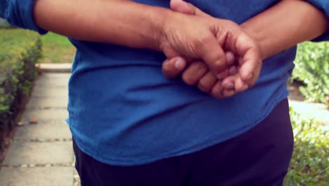 man walking with both hands behind his back