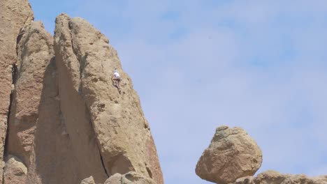 rock climber scaling a red rock structure
