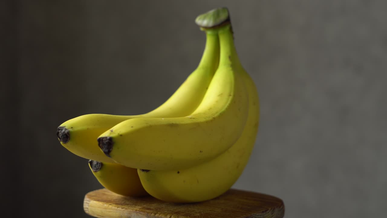 나무로 만든 받침대 위 에 있는 노란색 바나나