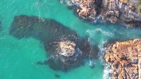 Stunning-Top-Down-View-of-a-Rugged-Cliffside-Meeting-the-Turbulent-Azure-Waters:-Nature's-Contrast-at-Play