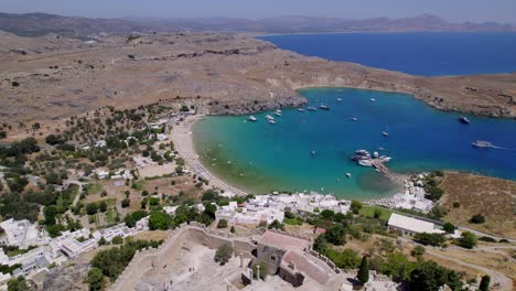 aerial view capturing the acropolis of lindos in greece and transitioning to the blue sea