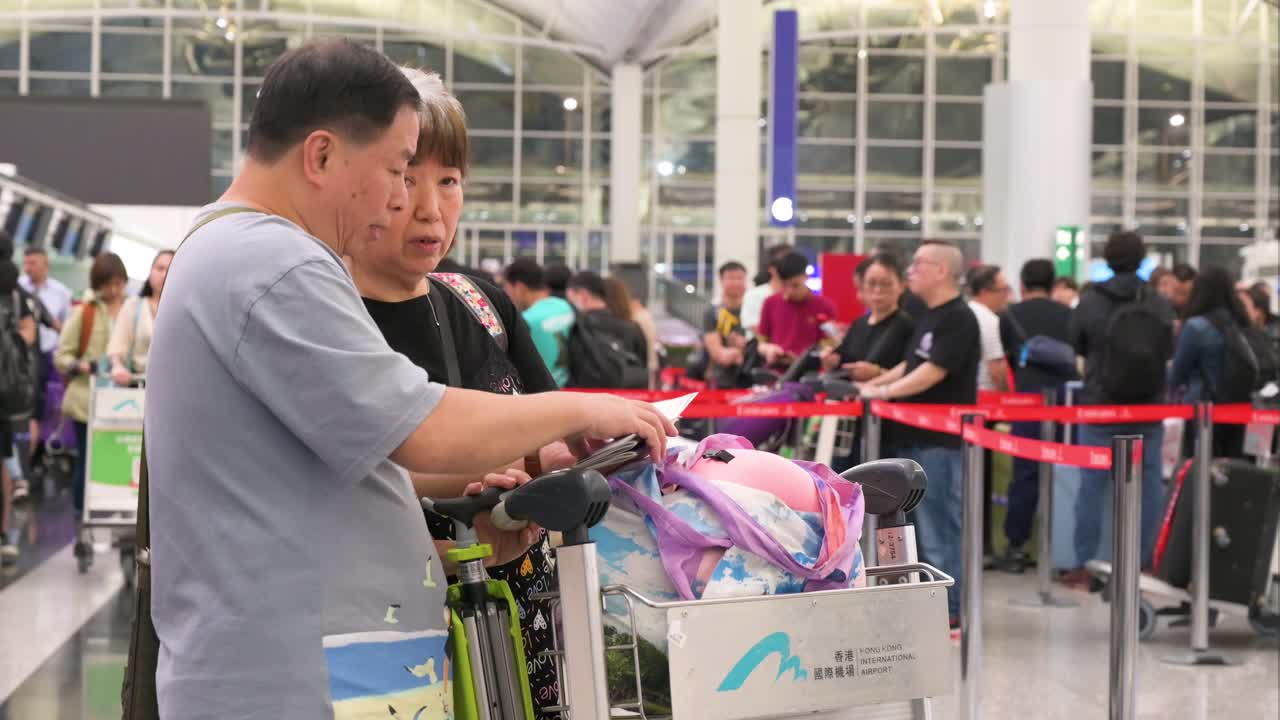 Travelers with luggage at Hong Kong International Airport