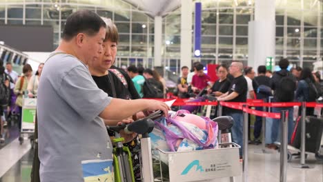 travelers with luggage at hong kong international airport