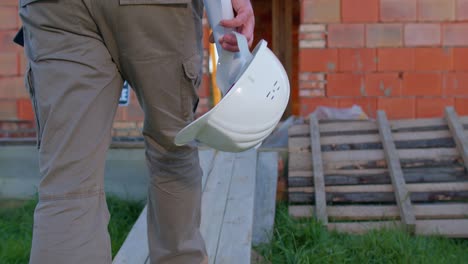 capataz de bienes raíces diseñador arquitecto de proyectos de construcción con casco caminando hacia el sitio de construcción