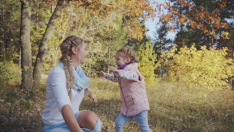 autumn forest fun with mom and daughter