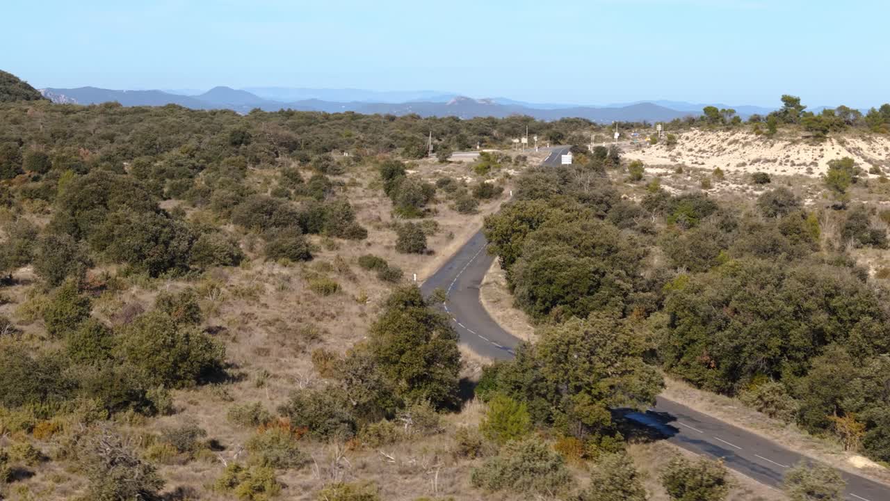 vista aérea por encima de un jeep conduciendo por la carretera a través del campo del sur de francia, el desierto
