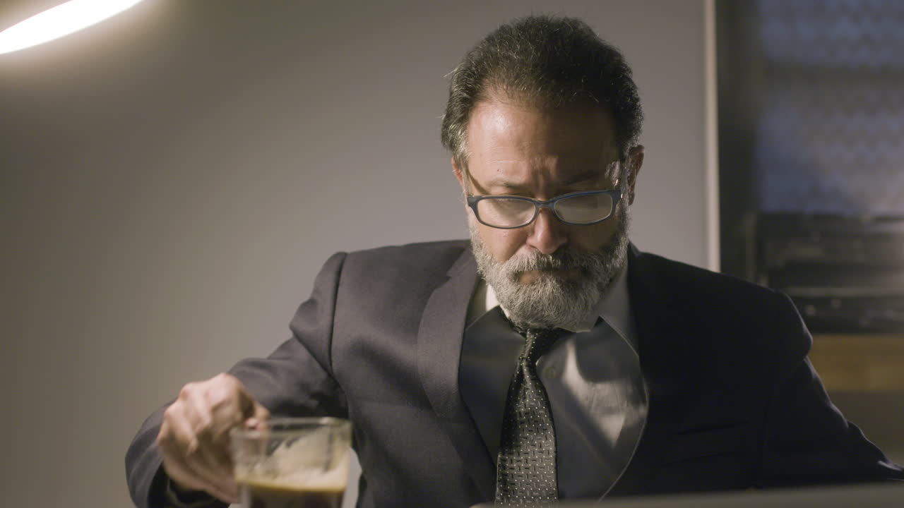 Uomo barbuto di mezza età che beve caffè forte
