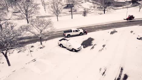 a pickup truck with a plow clears the road from the snow