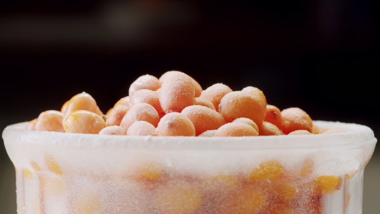 해바라기 건강한 베리 차 음료, 유리 항아리 및 잎을 가진 가지에 얼어붙은 익은 베리 어두운 나무 농촌 배경에  뷰, 피부, 심장, 혈관 및 면역 체계에 훌륭합니다.