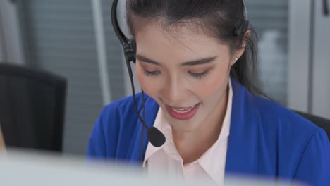 businesswoman wearing headset working actively in office