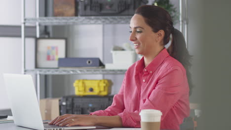 Businesswoman-In-Office-Making-Video-Call-At-Desk-On-Laptop