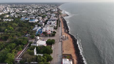early morning aerial footage shows the puducherry city and the mahatma gandhi statue. the entirety of puducherry, a lighthouse. the bengal bay waves. aerial footage of the city and the sea