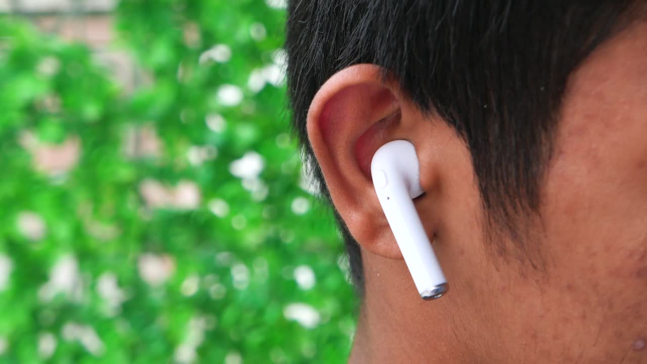 Close-up of a Person Wearing White Wireless Earbuds